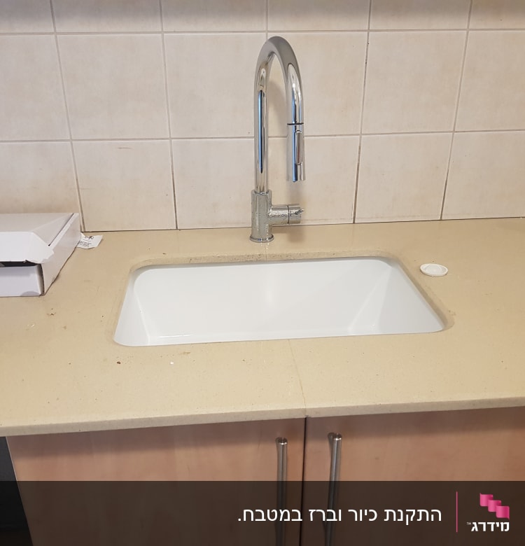 כיור מטבח עם ברז כרום על משטח עבודה
